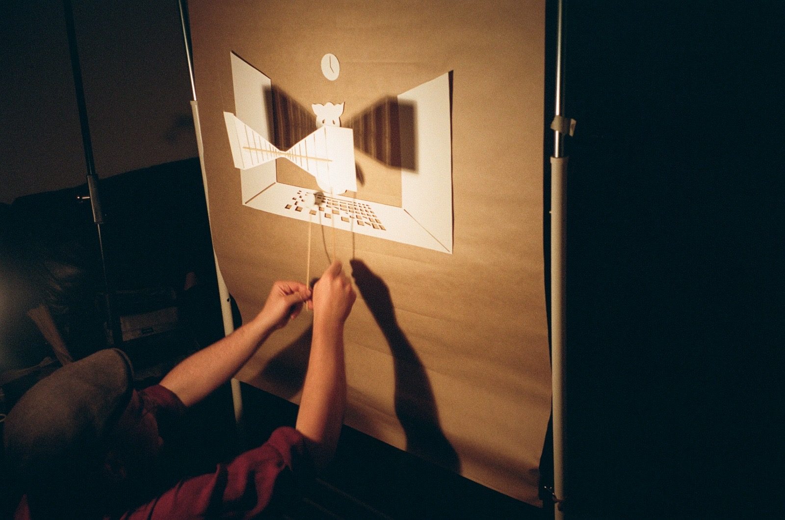 Puppets operated on sticks against the lit paper set